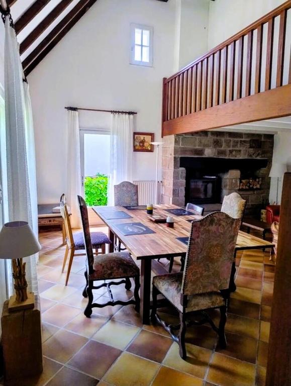une salle à manger avec une table et des chaises et une cheminée dans l'établissement Ty Carbon proche des plages, à Fouesnant