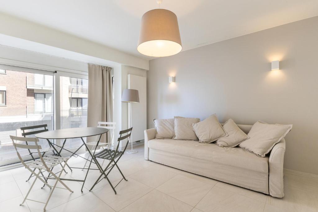 a living room with a couch and a table at Zeewind 0101 in Oostduinkerke