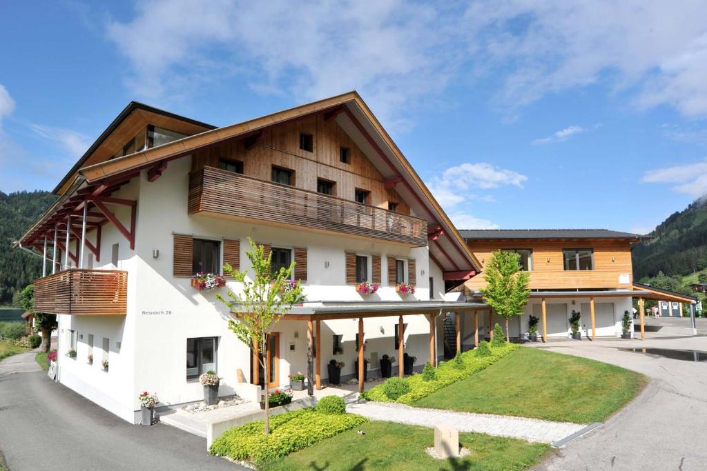 a large white building with a wooden roof at Ferienwohnung Birkenhof in Weissensee