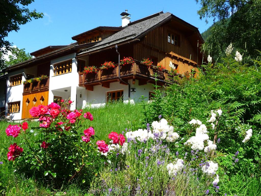 une maison avec des fleurs devant elle dans l'établissement Landhaus Fiausch, à Mallnitz