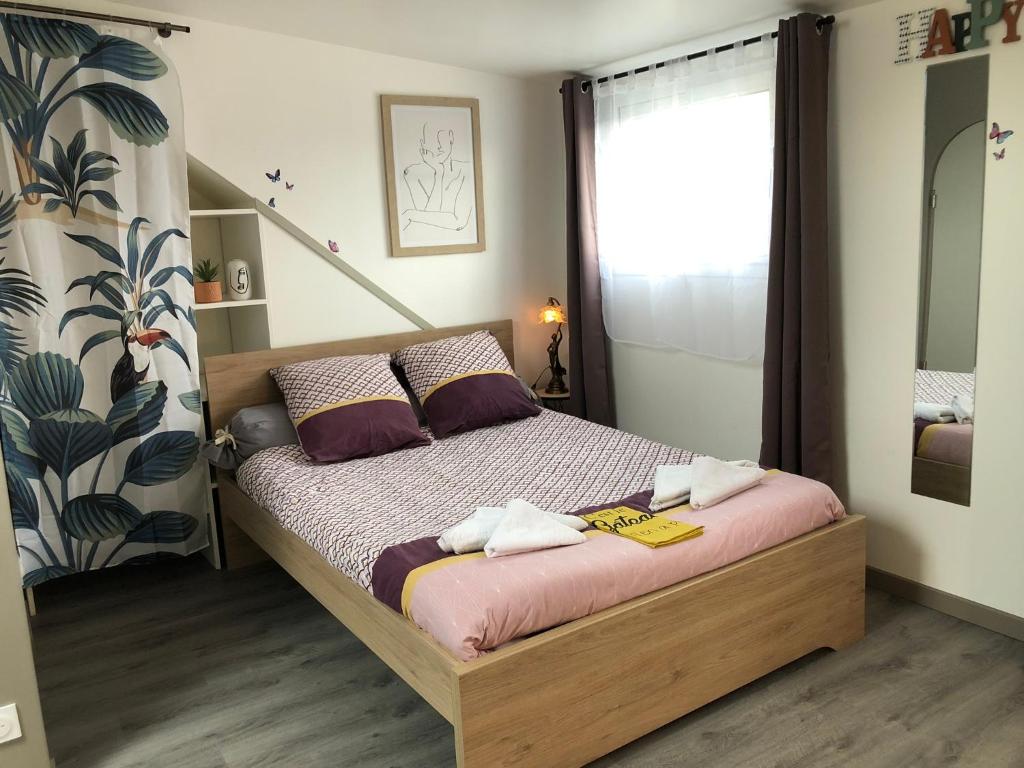 une chambre avec un lit avec deux serviettes dessus dans l'établissement Nid douillet Lorientais, à Lorient