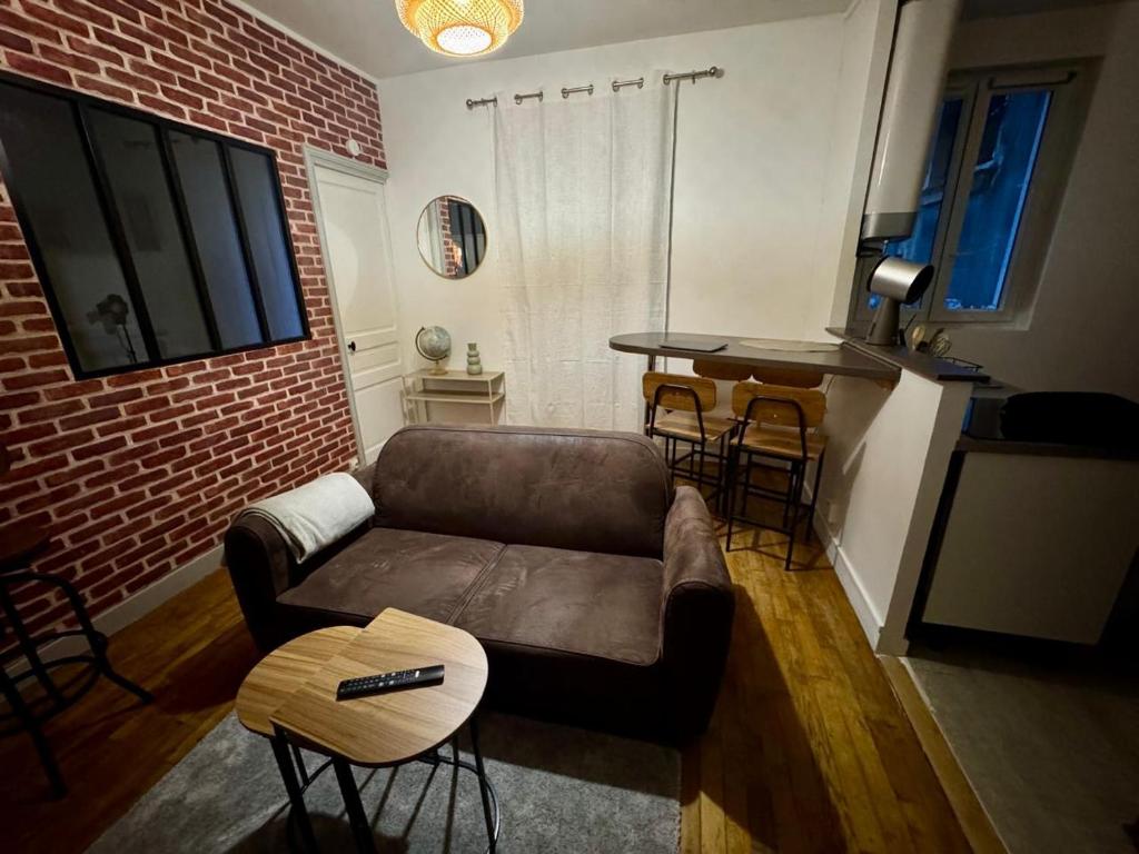 un salon avec un canapé et une table dans l'établissement Appartement lumineux aux portes de Paris Séjour longue durée idéal Pour Couple & Professionnels, à Malakoff