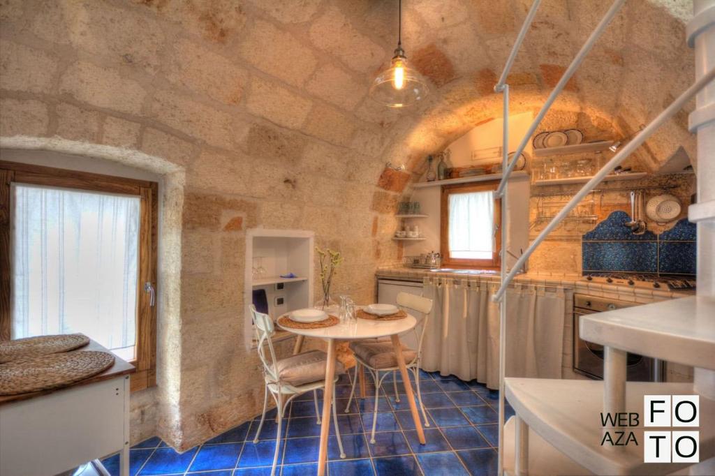 una cucina con tavolo al centro di una stanza di G.H.03 Polignano a Mare a Polignano a Mare