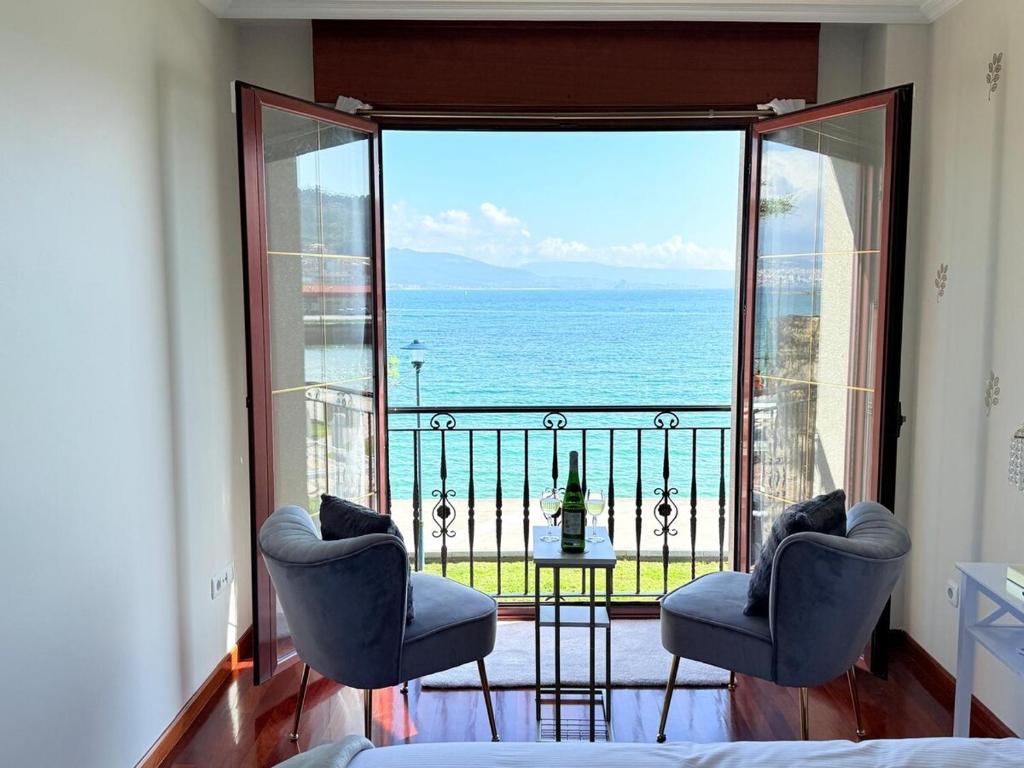 a bedroom with a balcony with a view of the ocean at Precioso amanecer frente al mar by CABANA Rentals in Cangas de Morrazo