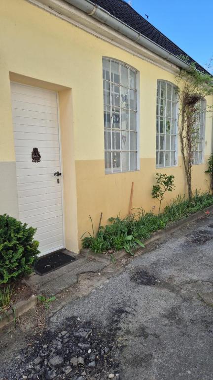 a yellow house with a white garage door at Alte Schmiede in Oldenburg