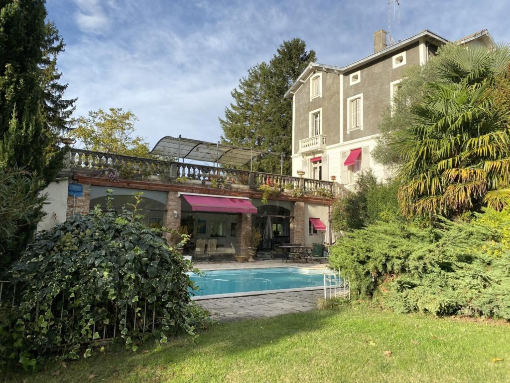une maison avec une piscine à côté d'un bâtiment dans l'établissement La Belle Demeure - Piscine privée, à Saverdun