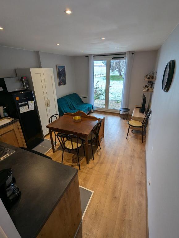 une cuisine et un salon avec une table et des chaises dans l'établissement Studio au rez-de-chaussée accès direct jardin, à Corrençon-en-Vercors