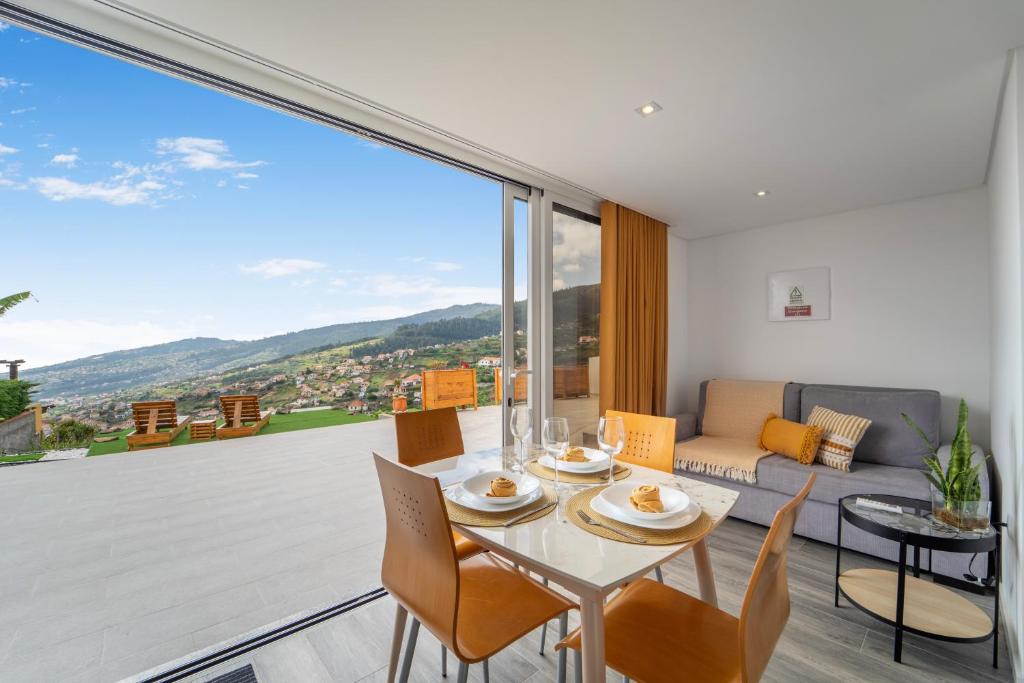 カリェタにあるBrand new private modern apartment with Patio and Sea Viewのテーブルと椅子と大きな窓のあるリビングルーム
