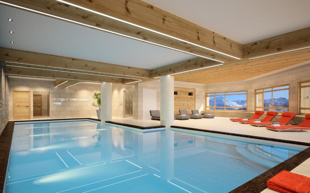 einen Pool in einem Haus mit einem Wohnzimmer in der Unterkunft Résidence Club mmv Le Cœur des Loges **** in Les Menuires