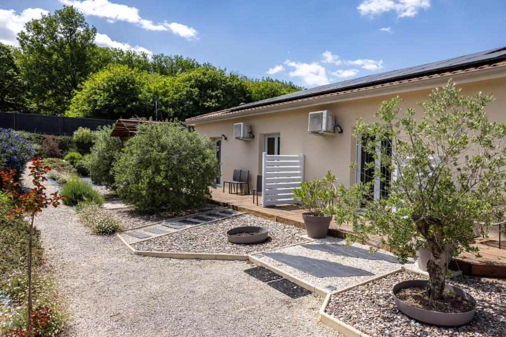 a garden with a house and some plants at "Notre Bastide" Maison et table d'hôtes traditionnelle et végétarienne, Piscine, jacuzzi, Clim, , à 5 mn de SARLAT in Marcillac-Saint-Quentin