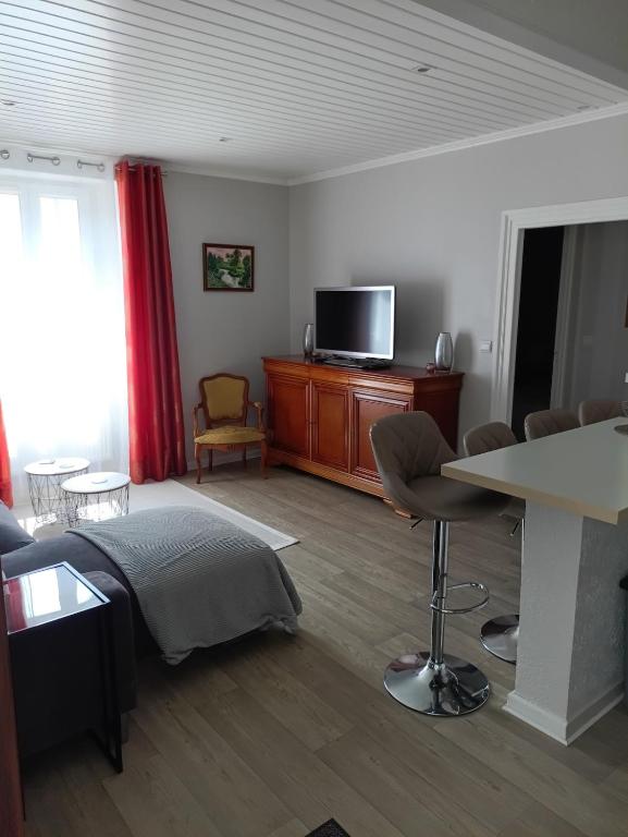 un salon avec un lit et une télévision dans l'établissement Le Bellevue, à Montceau-les-Mines