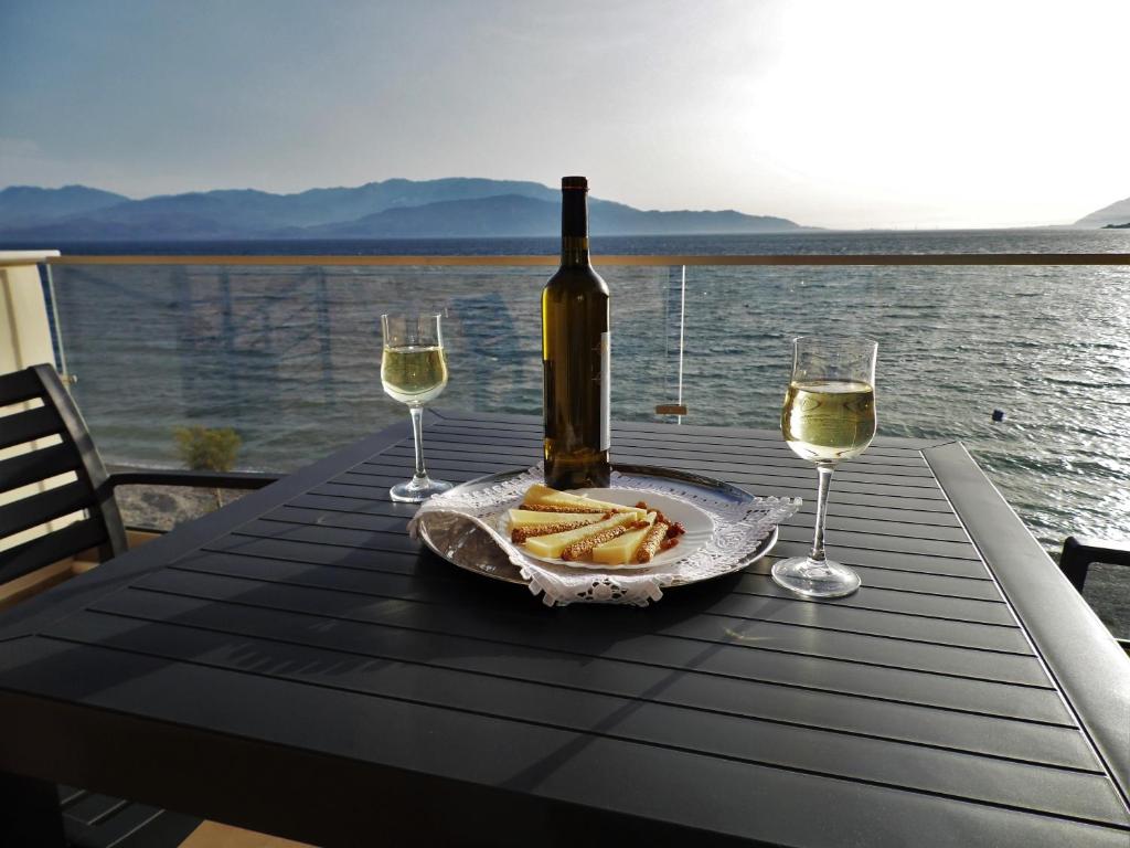 eine Flasche Wein und ein paar Weingläser auf dem Tisch in der Unterkunft Villa Thalassa in Paralía Sergoúlas