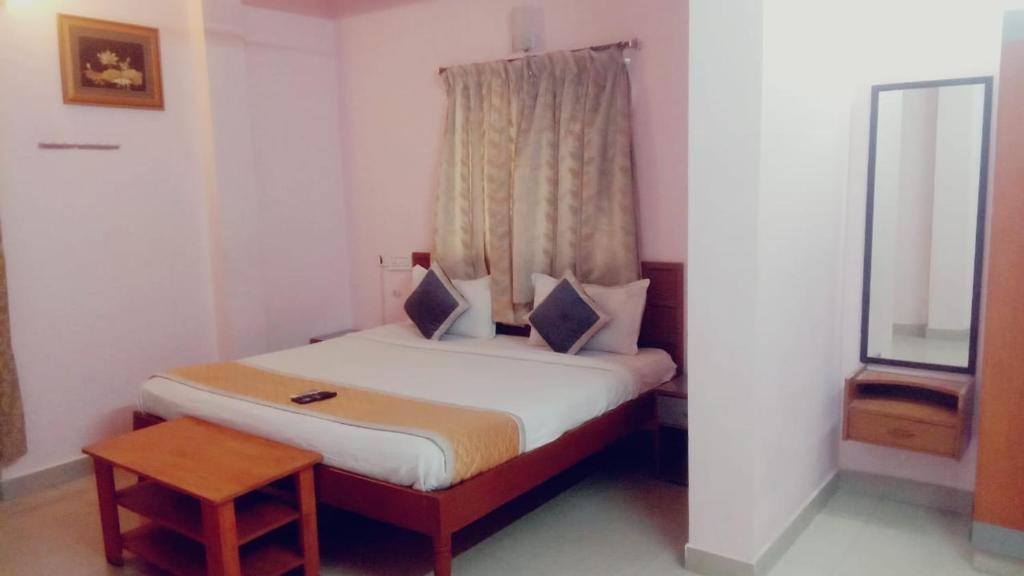 a small bed in a room with a window at Five Stones By Terra Hotel Mogappair in Chennai
