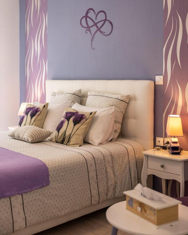 a bedroom with a bed with a purple wall at "Notre Bastide" Maison et table d'hôtes traditionnelle et végétarienne, Piscine, jacuzzi, Clim, , à 5 mn de SARLAT in Marcillac-Saint-Quentin