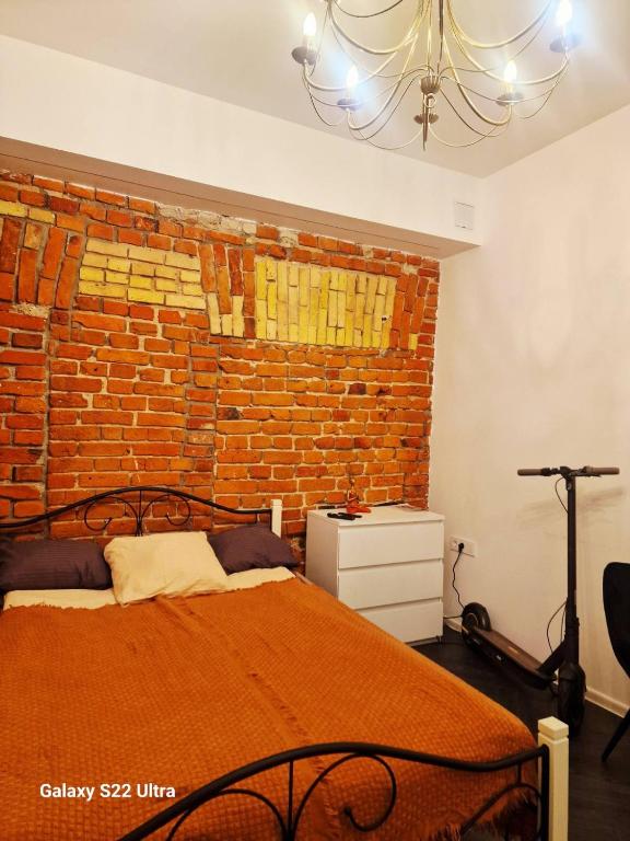 a bedroom with a brick wall and a bed at Kaunas Studios - RentA 18 in Kaunas