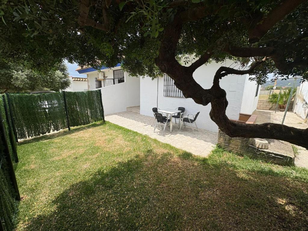 a table and chairs in a yard with a tree at Casa Nova de Bolonia in Bolonia