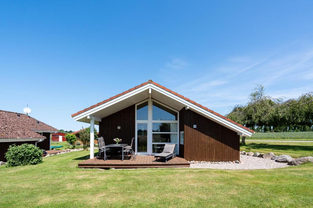 ノイシュタット・イン・ホルシュタインにあるObjekte im Umland Hof Ruhleben Haus Muschelsucherの小さな家で、デッキとパティオが付いています。