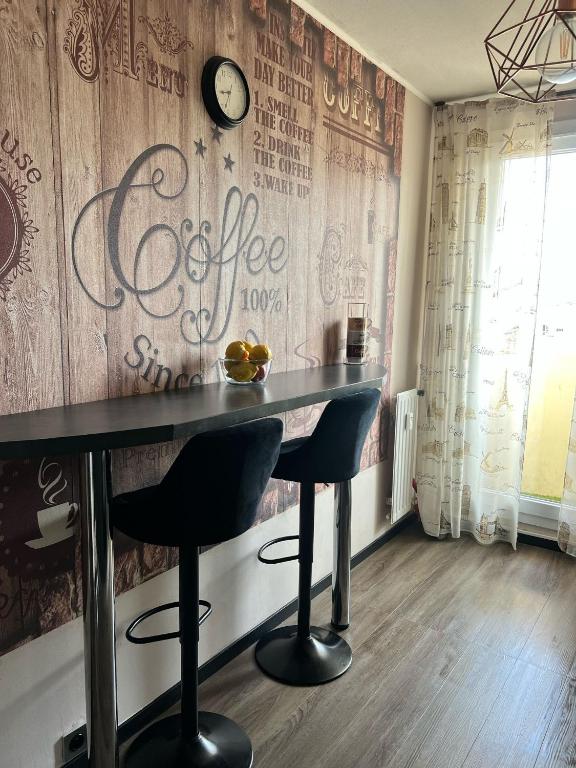 un bar avec deux tabourets et un mur avec une horloge dans l'établissement Résidence le Lyautey, à Nice