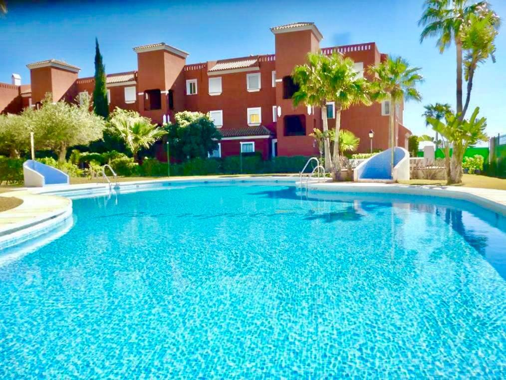 a large blue swimming pool in front of a building at CASA EVA Naturista, Vera Playa in Playas de Vera
