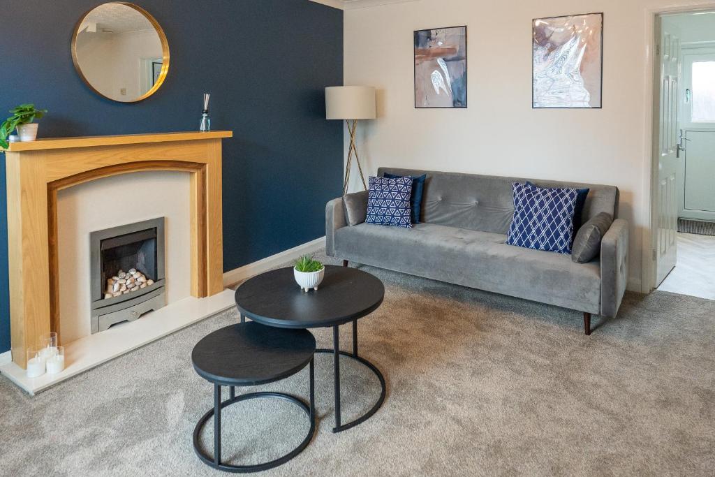 a living room with a couch and a table in front of a fireplace at Falcon Cottage in Sleaford