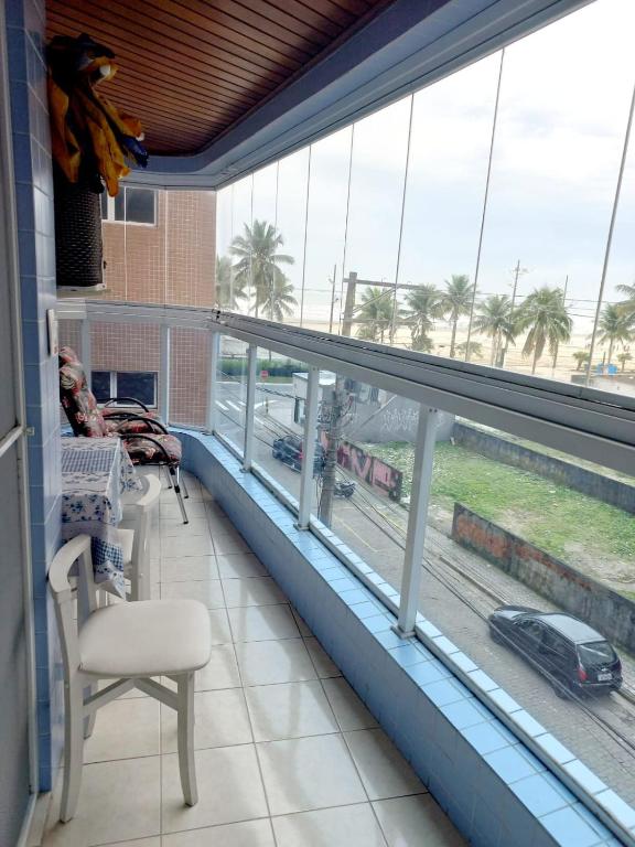 a room with a balcony with a view of a street at Apto Pé na Areia com Vista Mar, Churrasqueira e Espaço para 8 Pessoas in Praia Grande