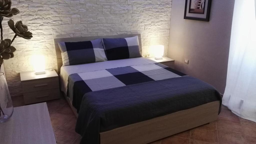 1 dormitorio con 1 cama con sábanas azules y blancas en Calarossa residence, en Siracusa