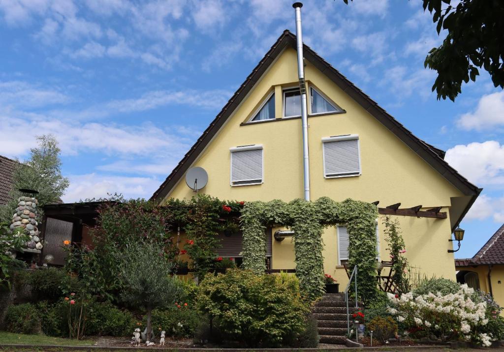 a yellow house with a gambrel roof at Ferienwohnung Honacker in Steißlingen