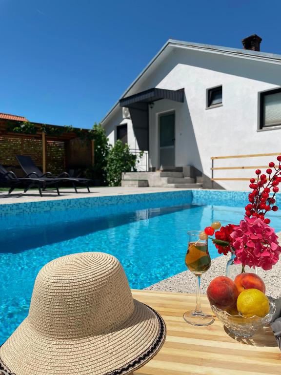 a hat sitting on a table next to a pool at Hills Holiday House in Mostar