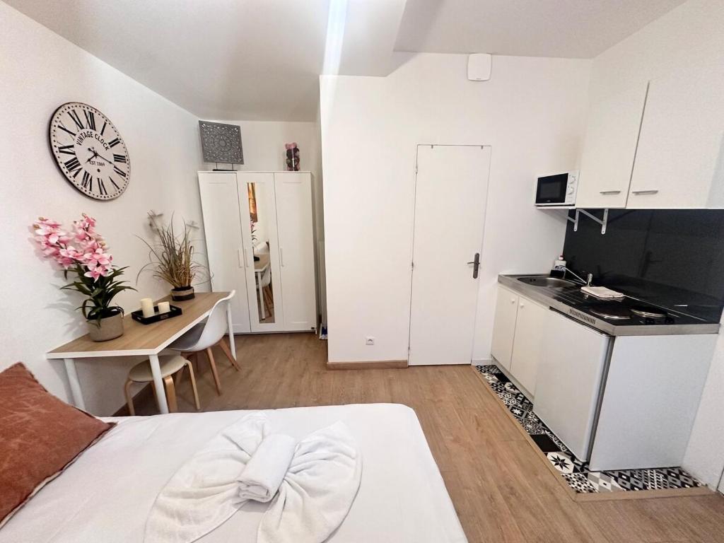 Cette chambre blanche dispose d'un lit, d'une table et d'une cuisine. dans l'établissement Chavalliaud 12 cocon en RDC proche centre-ville, à Reims