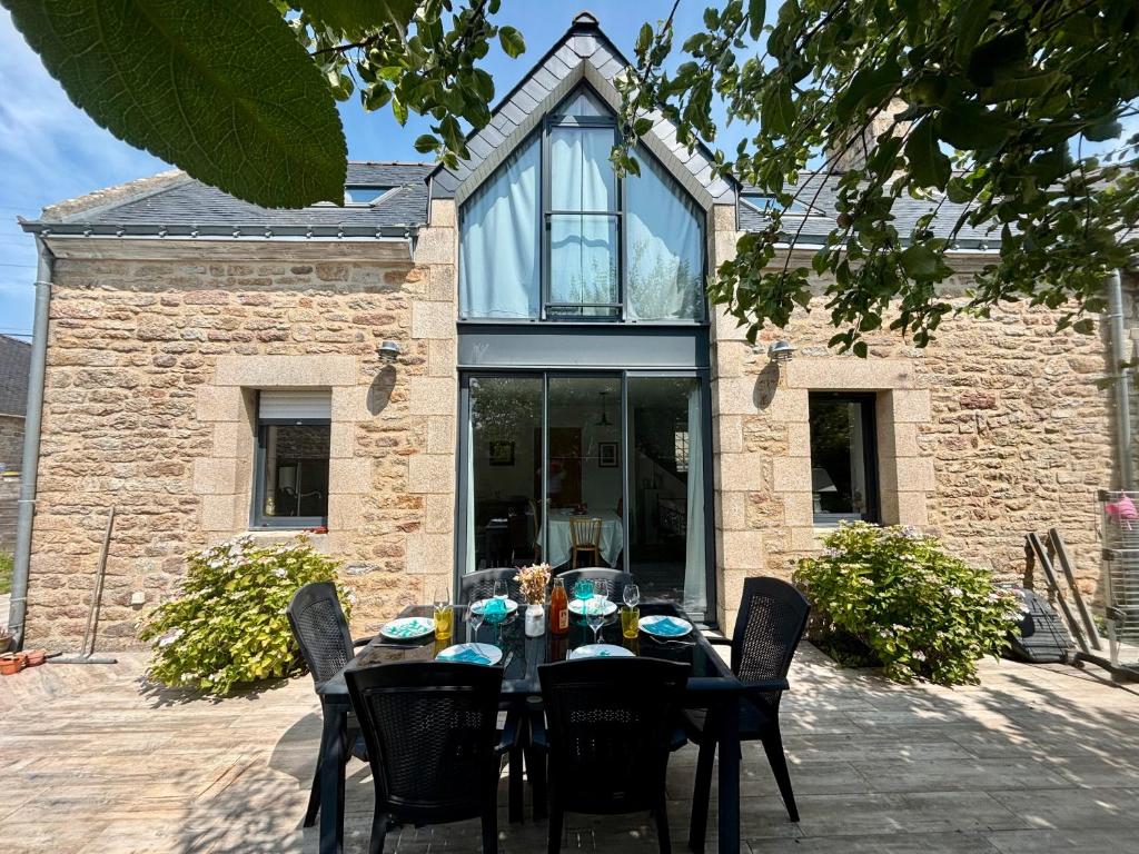 une table noire avec des chaises devant une maison dans l'établissement La Kervernoïse, à Ploemeur
