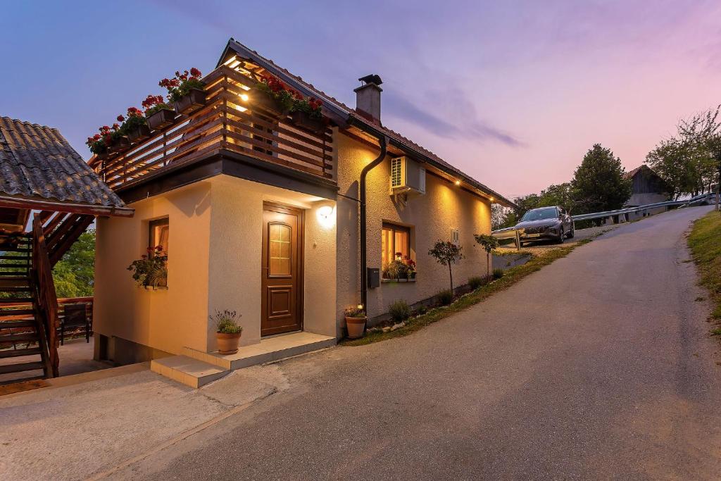 a house with flowers on the side of a road at Herbal Apartment Marjetka in Šentjur