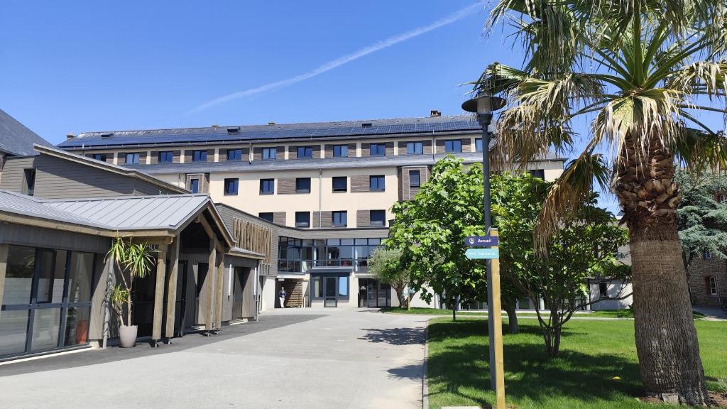 un bâtiment avec un palmier devant dans l'établissement Auberge de Jeunesse Youth Hostel Ethic étapes Saint Malo, à Saint-Malo