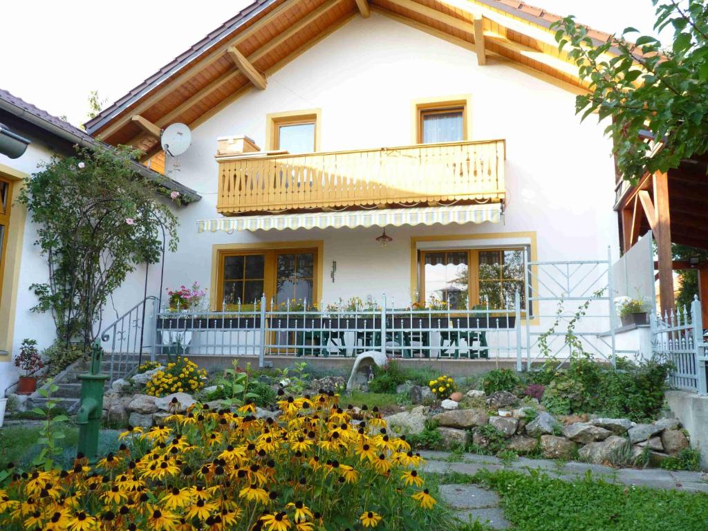 una casa con balcón y flores delante de ella en Ferienwohnung Hutterer, en Bad Griesbach