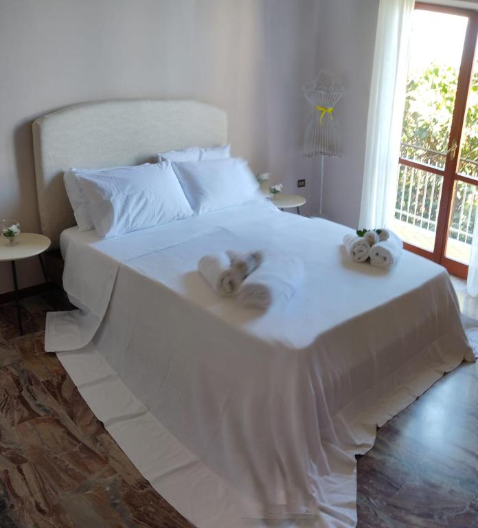 a white bed with two stuffed animals on it at Terry's House in Fondi