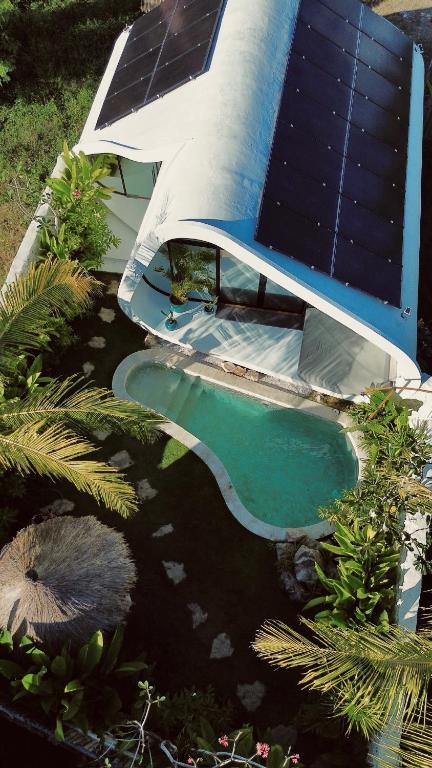 an aerial view of a swimming pool with a solar roof at Cheria Eco Lodge in Selong Belanak