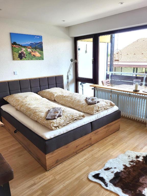 a large bed in a room with a large window at Ferienwohnung Zum Hochgrat in Oberstaufen