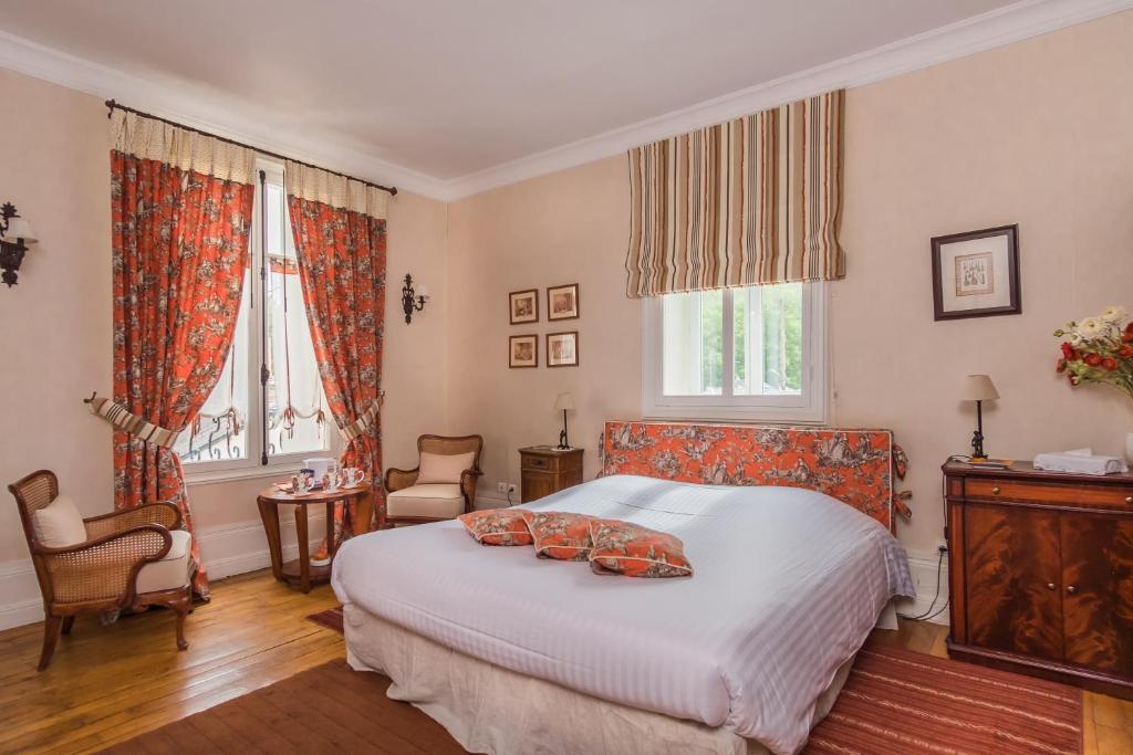 a bedroom with a bed and two windows at Manoir Du Parc (Adults only) in Amboise