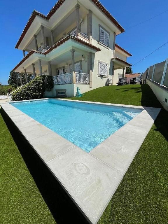 a house with a swimming pool in front of a house at Lux House in Ferreira