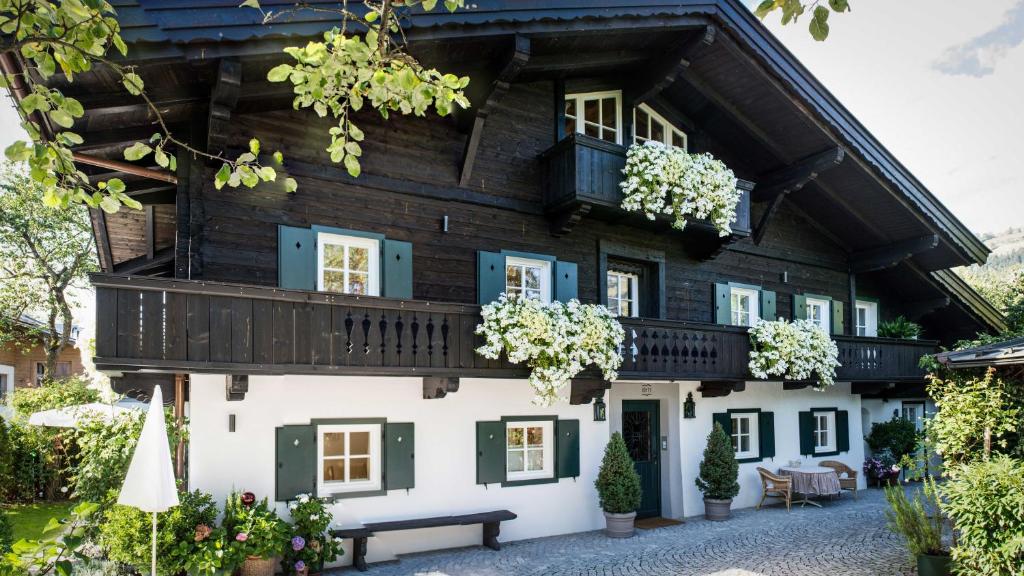 a house with a balcony with flowers on it at Weberhaus - Adults Only in Kitzbühel