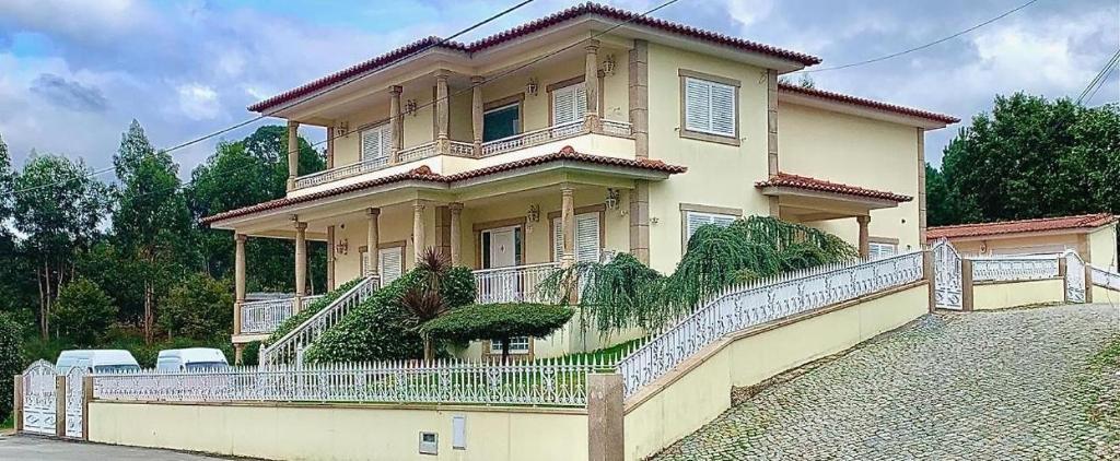 una casa grande con una valla delante en Lux House, en Ferreira