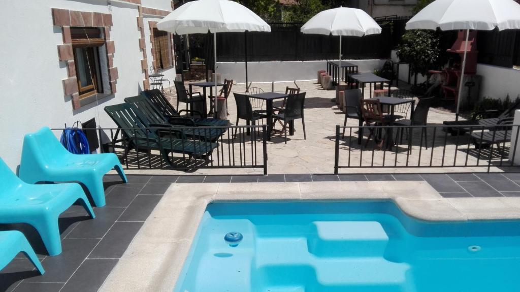 una piscina con sillas, una mesa y un patio en La Casa Blanca del Alto Tajo, en Ablanque