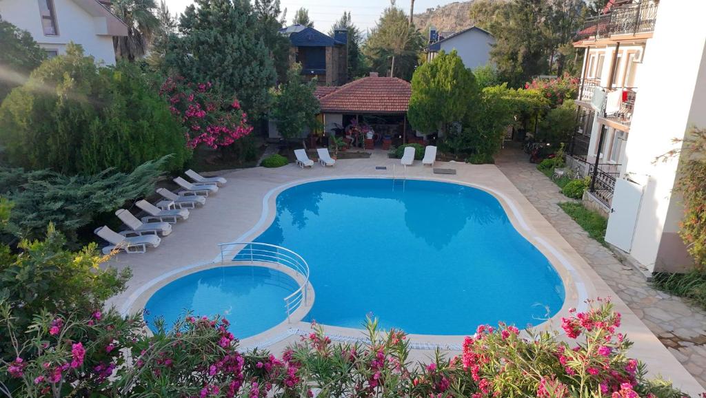 a swimming pool in a yard with chairs and flowers at Angels Garden Dalyan in Dalyan