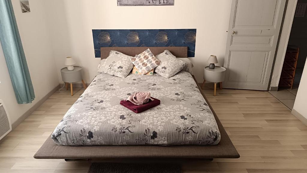 une chambre avec un grand lit avec un peignoir dessus dans l'établissement appartement villa Marie Fanny, à Arles