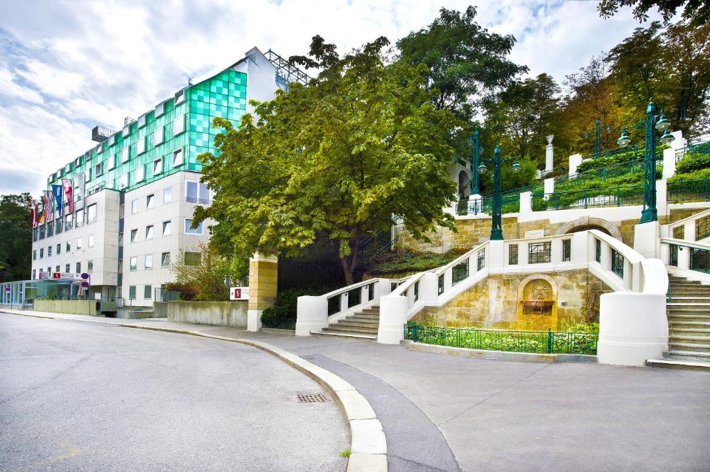 una strada con un ponte bianco e un edificio di Hotel Strudlhof Vienna a Vienna