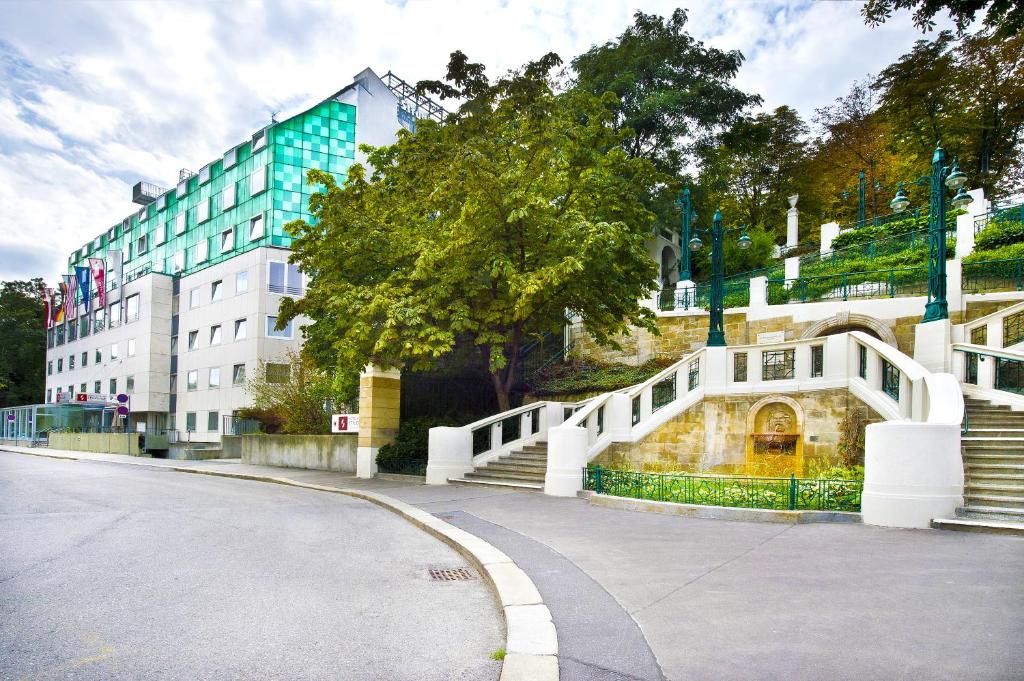 a street with a white bridge and a building at Hotel Strudlhof Vienna in Vienna