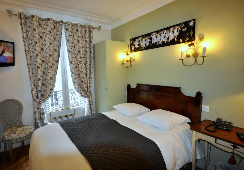 a bedroom with a bed and a desk and a window at Hotel des Bains in Paris