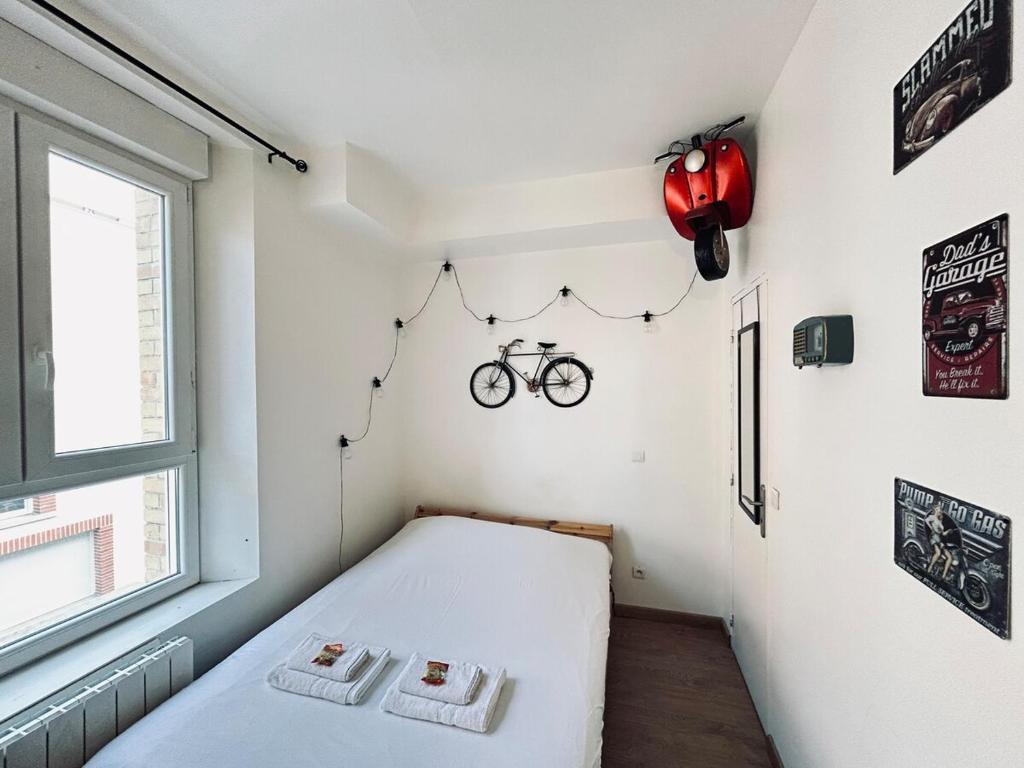 - une chambre avec un lit et un vélo sur le mur dans l'établissement Lys 7 magnifique studio tout équipé proche de tout, à Reims