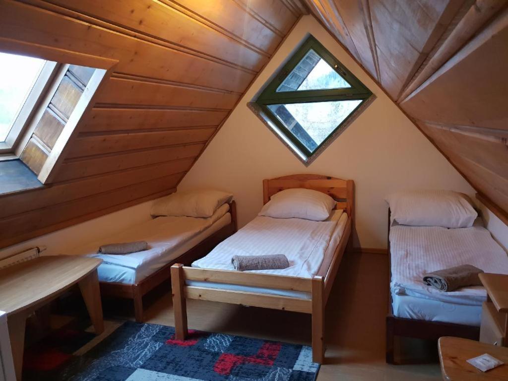 two beds in a attic room with two windows at Apartament Pokoje u Jacka Zakopane PKP 700 Centrum 1200 in Zakopane