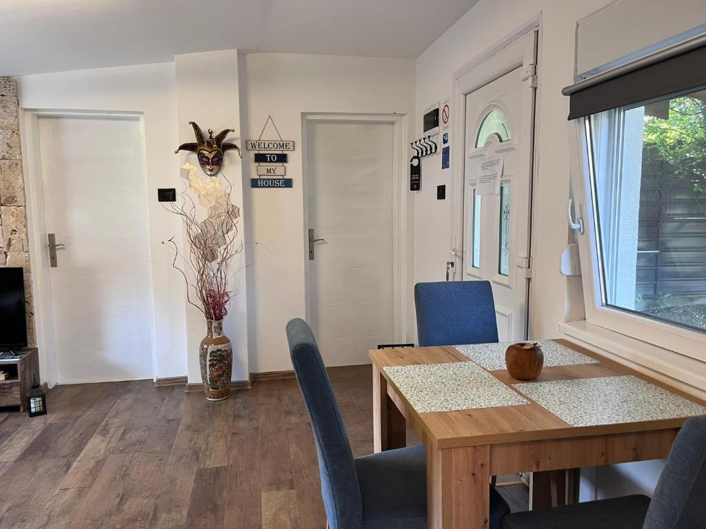 una sala da pranzo con tavolo in legno e sedie blu di Vasilija a Sremski Karlovci