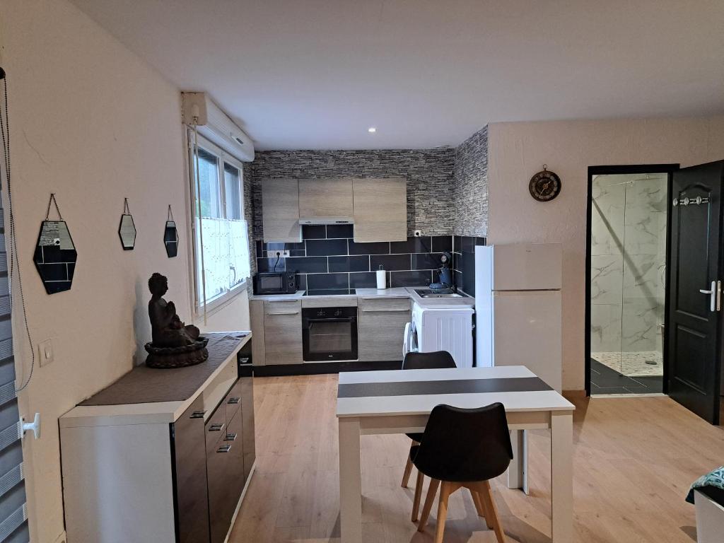 une cuisine avec une table et des chaises dans une pièce dans l'établissement le studio d isa, à Lens